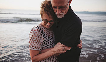 happy middle age couple at beach