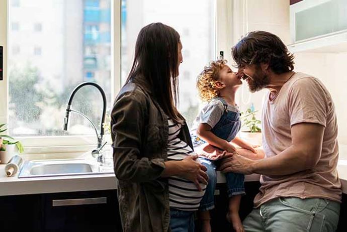 mom dad and daughter standing in kitchen