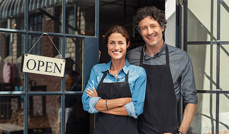 Male And Female Business Owners Standing In Shop Door